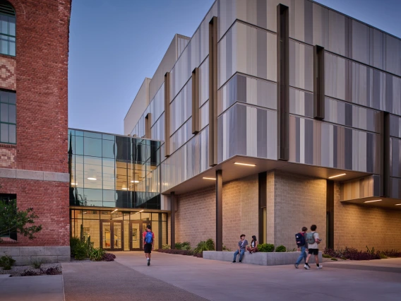 student walking by Commons building